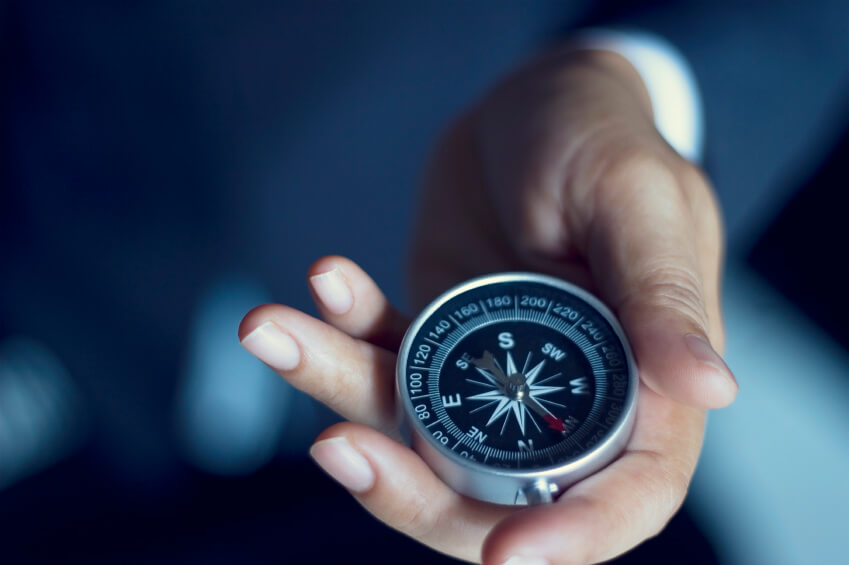 Businessman with a compass holding in hand, color tone film look